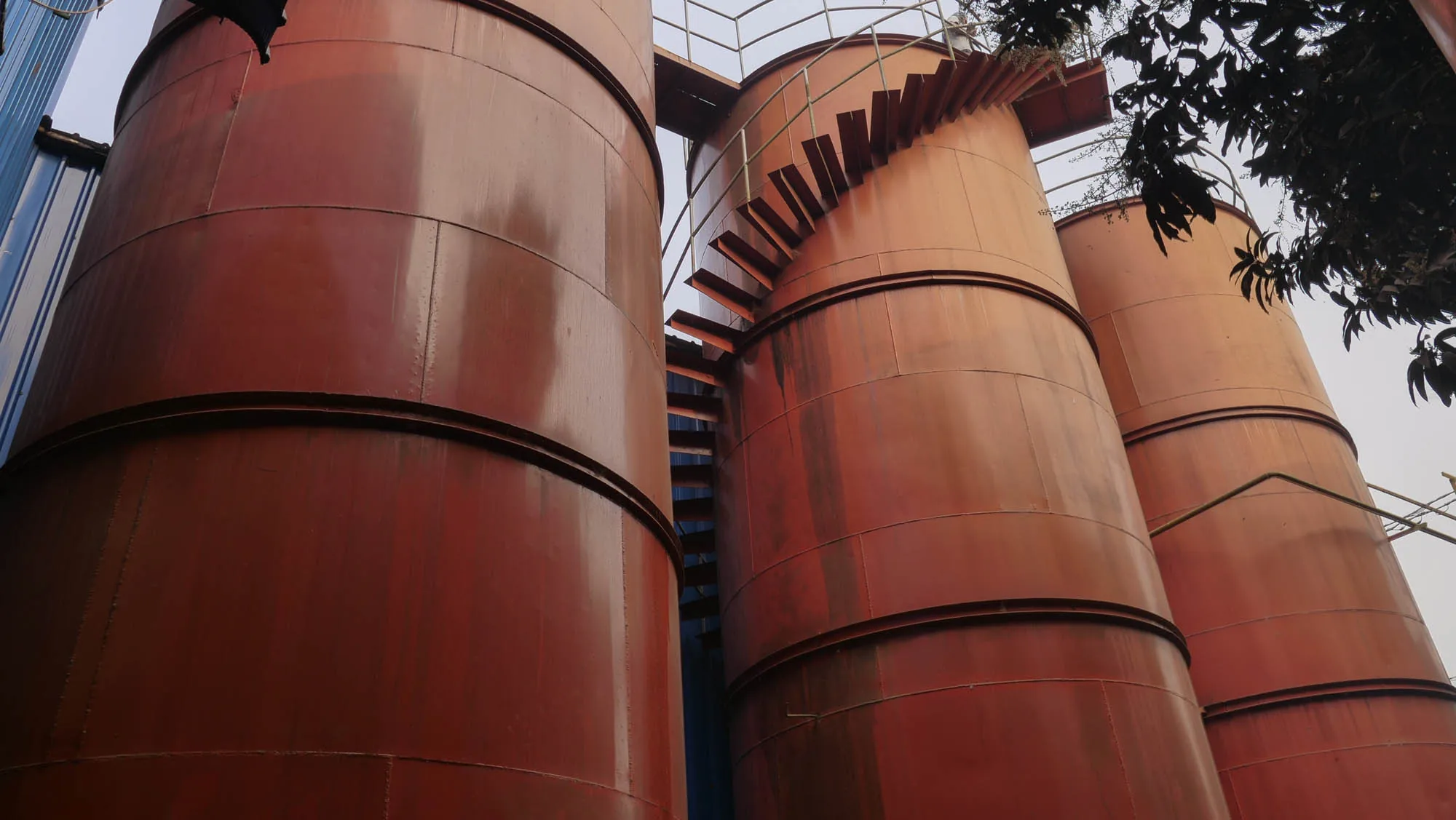 Shufola factory exterior — three cylindrical sesame-oil storage silos at Ullapara, Shirajgonj
